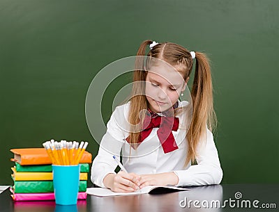 Schoolgirl wrote in a notebook in the classroom Stock Photo
