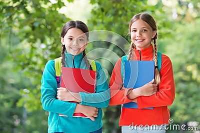Schoolgirls with backpacks and textbooks in forest, summer camp activity concept Stock Photo