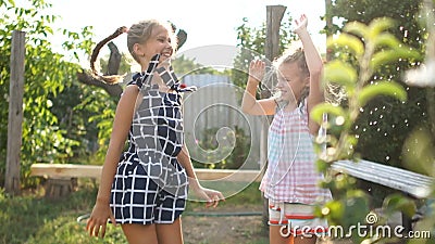 Schoolgirls on vacation in the village. Two girls have fun jumping under water, children have fun stock video footage Schoolgirls on vacation in the village. Two girls have fun jumping under water, children have fun stock video footage