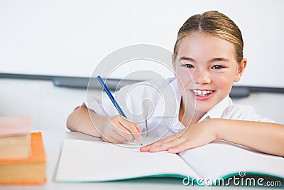 Schoolkid doing homework in classroom Stock Photo