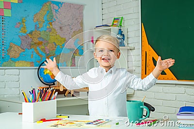 Schoolkid or preschooler learn. Little student boy happy with an excellent mark. School interiors. Kid is learning in Stock Photo