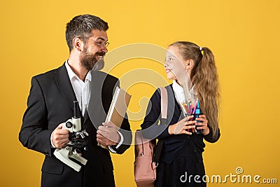 Schoolkid and a teacher on studio background. Portrait of tutor with school girl. Stock Photo