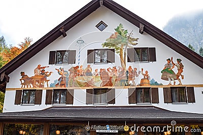 SCHWANGAU, GERMANY - OKTOBER 09, 2018: Painted scene of feast on the wall of a house in a village in the Alps Editorial Stock Photo