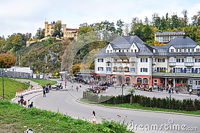 SCHWANGAU, GERMANY - OKTOBER 09, 2018: View of Hohenschwangau castle and beautiful old building with tourists in Alps Editorial Stock Photo