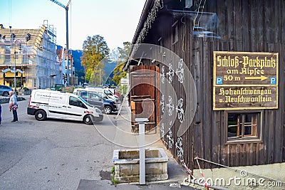 SCHWANGAU, GERMANY - OKTOBER 09, 2018: Wooden barn and car parking with direction indicator on the wall Editorial Stock Photo