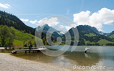 Schwarzsee, FR / Switzerland - 1 June 2019: tourists enjoy the summer lakeside view at the Schwarzsee Lake in the Swiss Alps in Editorial Stock Photo