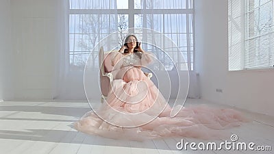 Schönes junges schwangeres Mädchen im rosa langen Kleid stock video footage Schönes junges schwangeres Mädchen im rosa langen Kleid stock video footage