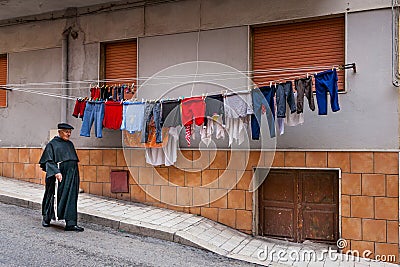 SCIACCA, ITALY - October 18, 2009: the priest crossing the road Editorial Stock Photo