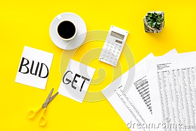 Sciccors and paper with word budget, coffee and plan for budget reducing on yellow background top view Stock Photo