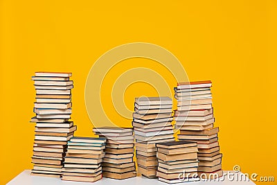 science education stack of books on a yellow background teaching literacy Stock Photo