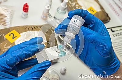 Scientific police hold positive drug reagent at crime lab Stock Photo