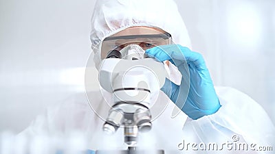 Scientist is analyzing samples using a microscope in a laboratory setting. Close-up of a focused researcher in a Stock Photo