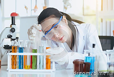 Scientist beautiful woman working and putting medical chemicals sample in test tube at lab office,Close up Stock Photo