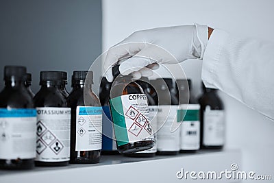 Scientist, bottle and copper in chemistry lab on shelf for pharma, analysis and medicine development. Science person Stock Photo