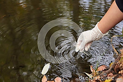 A scientist collects river water in a glass beaker Stock Photo