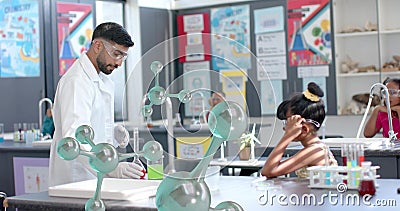 Scientist conducting experiment over image of molecular structures in classroom Stock Photo