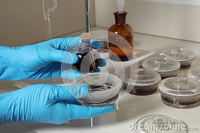 Scientist doing nitrogen titration of soil sample at table. Laboratory research Stock Photo