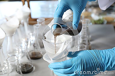 Scientist filtering soil samples at table. Laboratory analysis Stock Photo