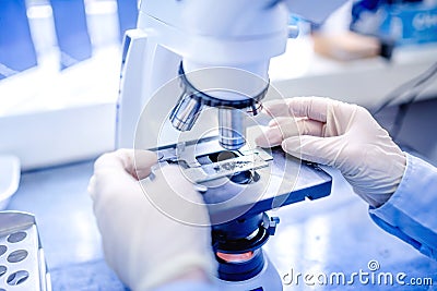 Scientist hands with microscope, examining samples and liquid. Medical research with technical equipment Stock Photo