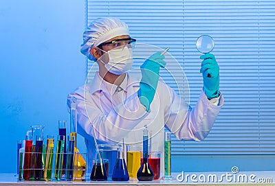 Scientist holding pen with magnifying glass Stock Photo