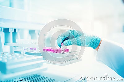 Scientist holding sample of experiment in pharmaceutical environment. close up of medical details Stock Photo