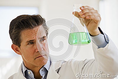 Scientist holding up jar of chemicals Stock Photo