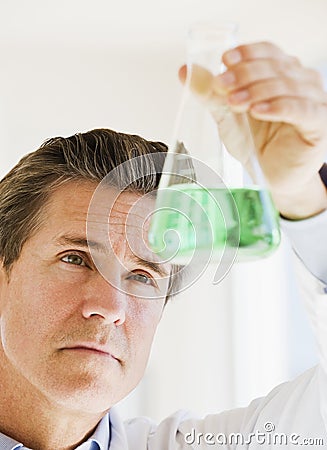 Scientist holding up jar of chemicals Stock Photo