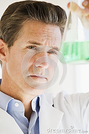 Scientist holding up jar of chemicals Stock Photo