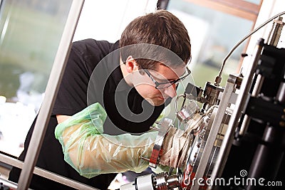 Scientist inserts hand to laser deposition chamber Stock Photo