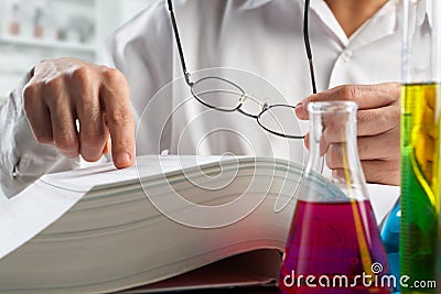 Scientist looking for data in journal Stock Photo