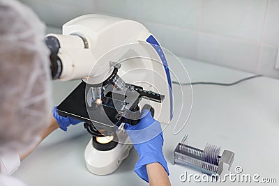 Scientist looking through a microscope in a laboratory. scientist doing some research. Stock Photo