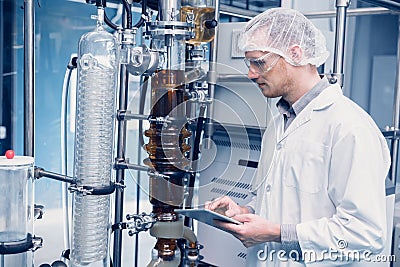 Scientist man working Cannabis CBD oil extraction for medical Science lab. Hemp oil extraction Thin Film Distillation Machine in Stock Photo