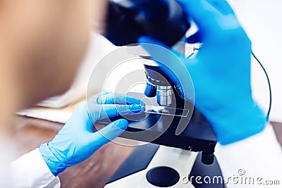 Scientist with microscope to examine small chemical probes. Medical equipment and laboratory samples Stock Photo