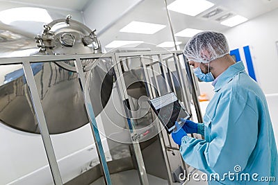 Scientist stand near chromed barrels Stock Photo