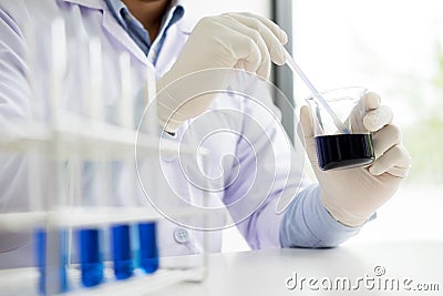 scientist stirs reagents beaker in Science Laboratory. Stock Photo