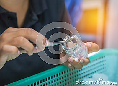 Scientist student girl biotechnology using forceps for small pieces plant tissue culture in bottle Stock Photo