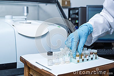 Scientist Women Check Sample in Vials for Analysis by Fourier Transform Infrared Spectroscopy FTIR Instrument Stock Photo