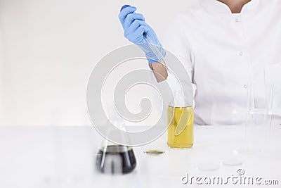 Scientist working with pharmaceutical cbd oil in a laboratory with glass dropper and a bowl Stock Photo