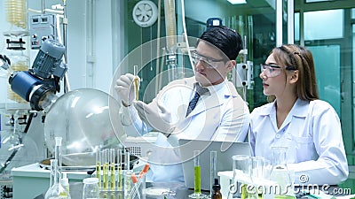 Scientists and assistants are in the oil and cannabis seed extractor room. Stock Photo
