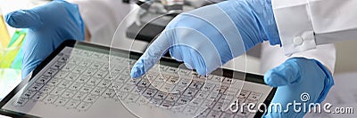 Scientists chemists looking at digital tablet with periodic table of elements in laboratory Stock Photo