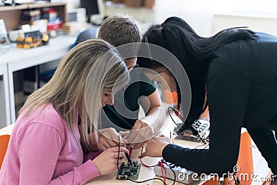 Scientists engineers designing small human robot, setting artificial intelligence humanoid robot. Artificial intelligence, Stock Photo
