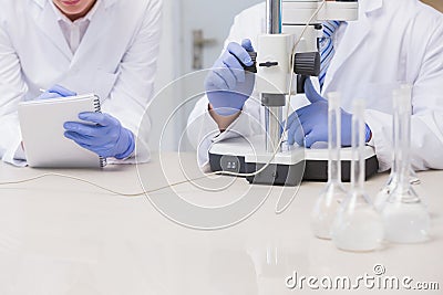 Scientists examining something with the microscope Stock Photo