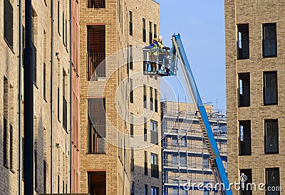 Glasgow, UK, 13th January 2024, Scissor lift being operated by construction workmen for safe access at height Editorial Stock Photo