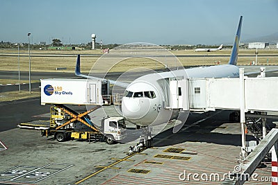 Scissor lift and catering truck alongside a passenger jet Editorial Stock Photo