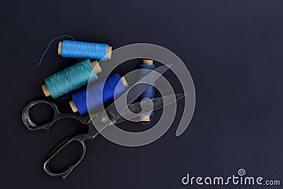 Scissor and threads. Tailoring tools and accessories on black ba Stock Photo