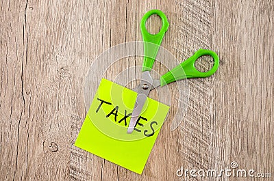 Scissors cut out the word `taxes` Stock Photo