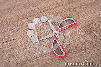 Scissors and some dollar coins Stock Photo