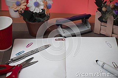 Scissors and stationary with checkered math book above textured backdrop. Writing equipment on an unplain floor Stock Photo