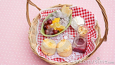 Scone, strawberry jam, almond, and mixed fruit in a basket Stock Photo