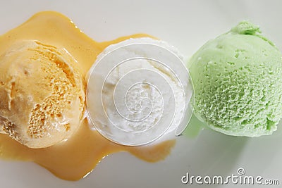 Scoop of delicious real fresh ice cream in Mango, Vanilla and Pistachio flavour. Stock Photo